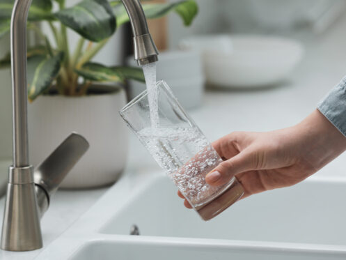 A woman getting a clean, cool glass of water in San Jose.